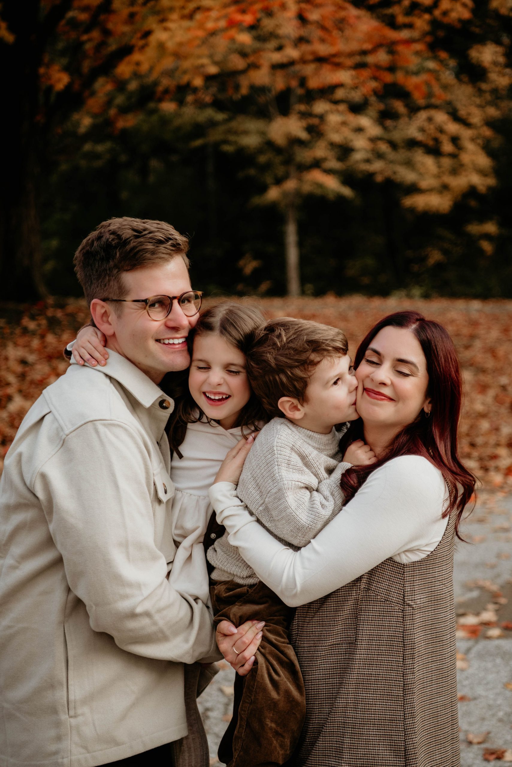 A father laughing with his young children outdoors